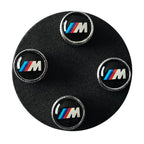 BMW tyre valve stem caps on a black foam display circle