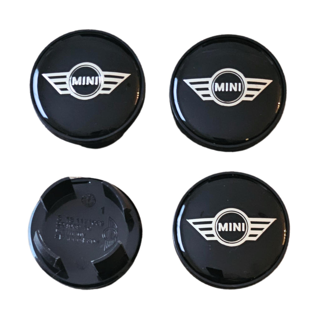 Four mini wing logo wheel centre hub caps on a white background