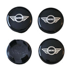 Four mini wing logo wheel centre hub caps on a white background
