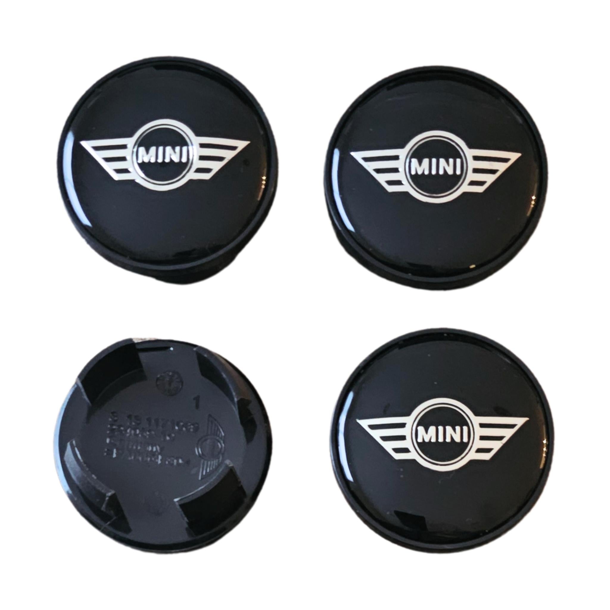 Four mini wing logo wheel centre hub caps on a white background
