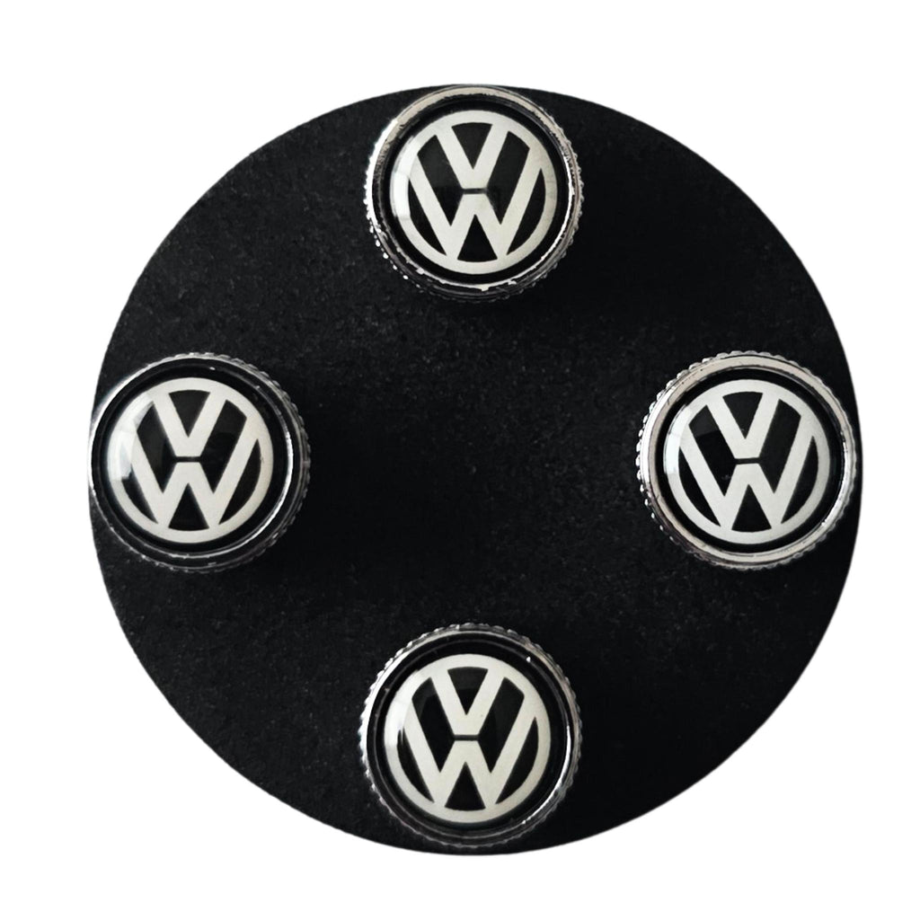 Set of Volkswagen VW tyre valve caps on a black base