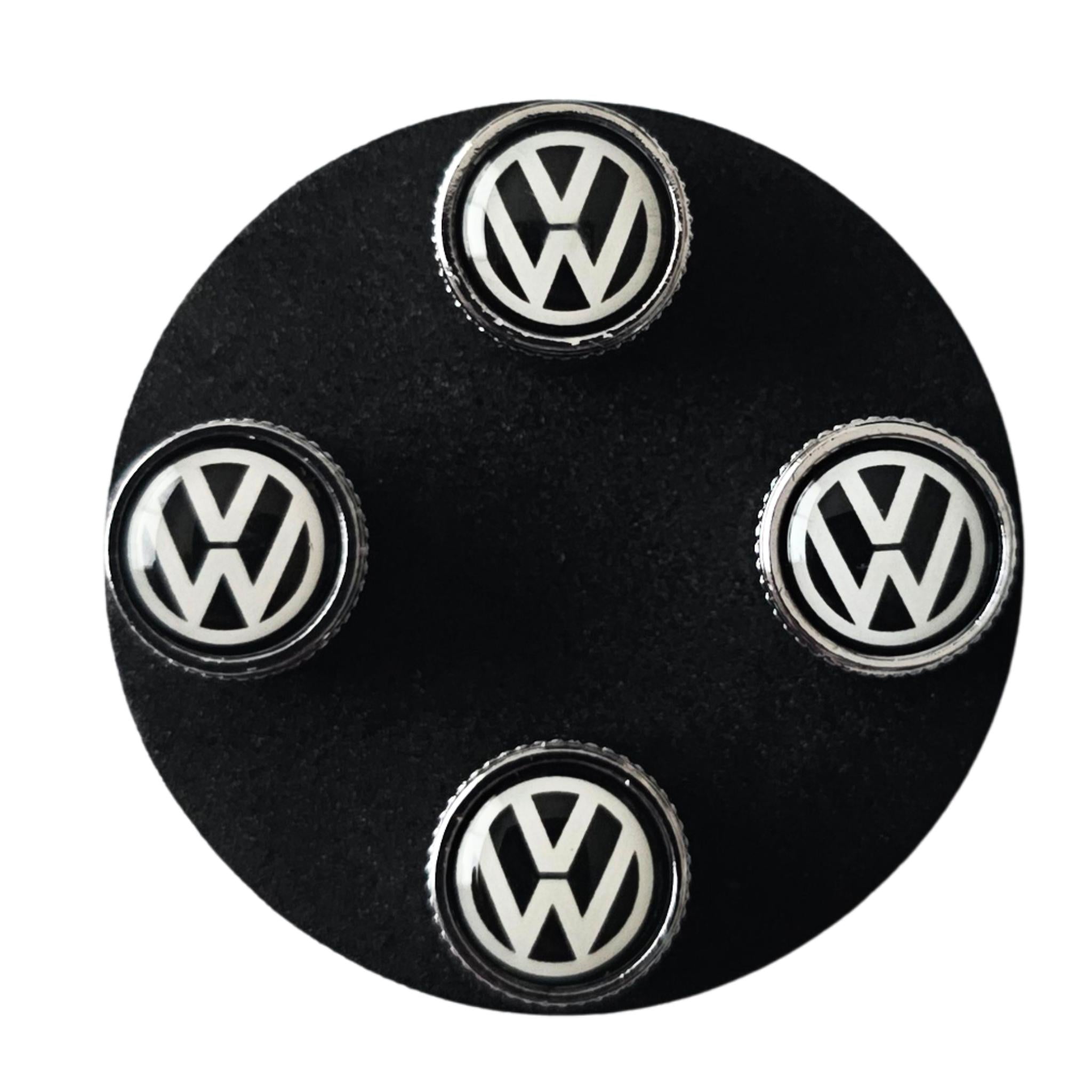 Set of Volkswagen VW tyre valve caps on a black base