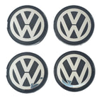 Four 63mm VW Volkswagen logo wheel center caps on a white background