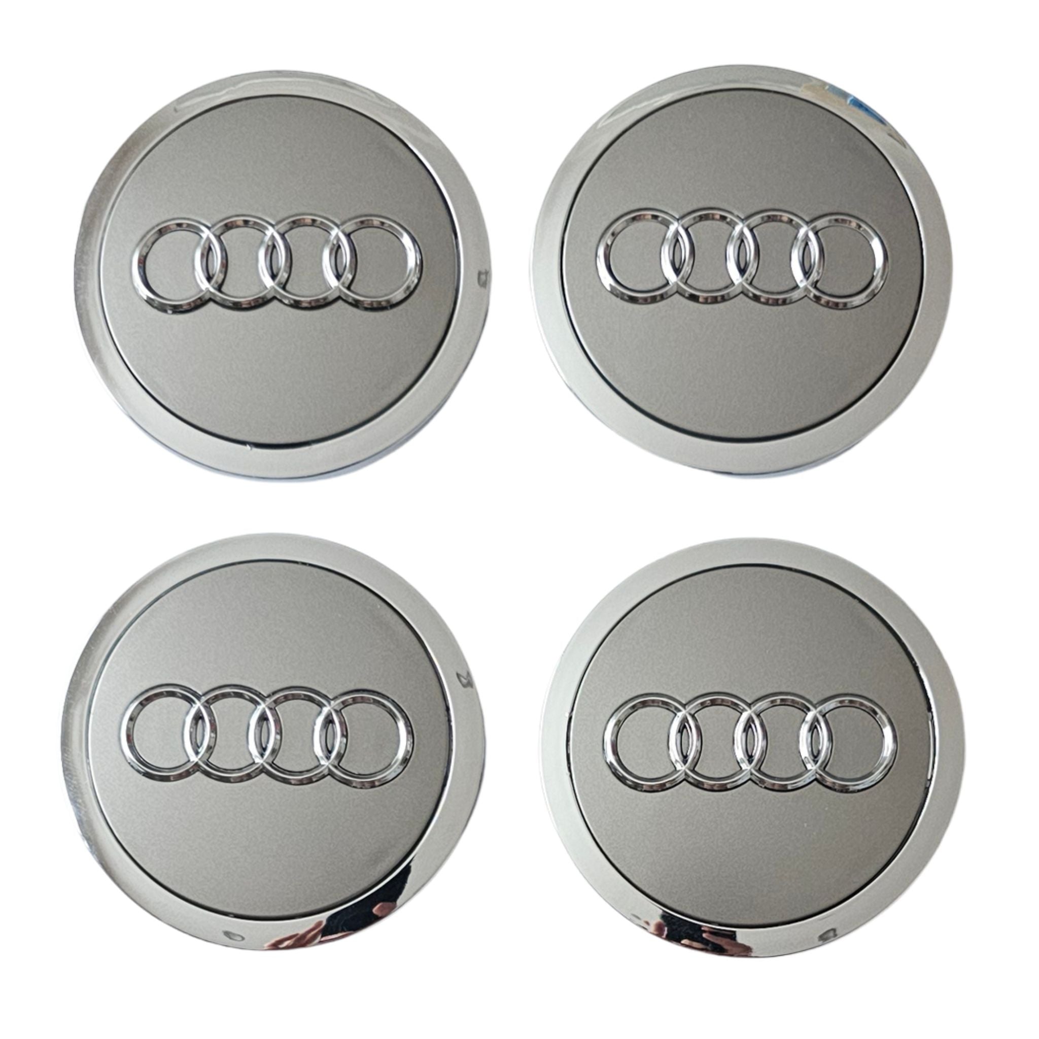Four Silver Grey Audi logo car wheel center caps on a white background