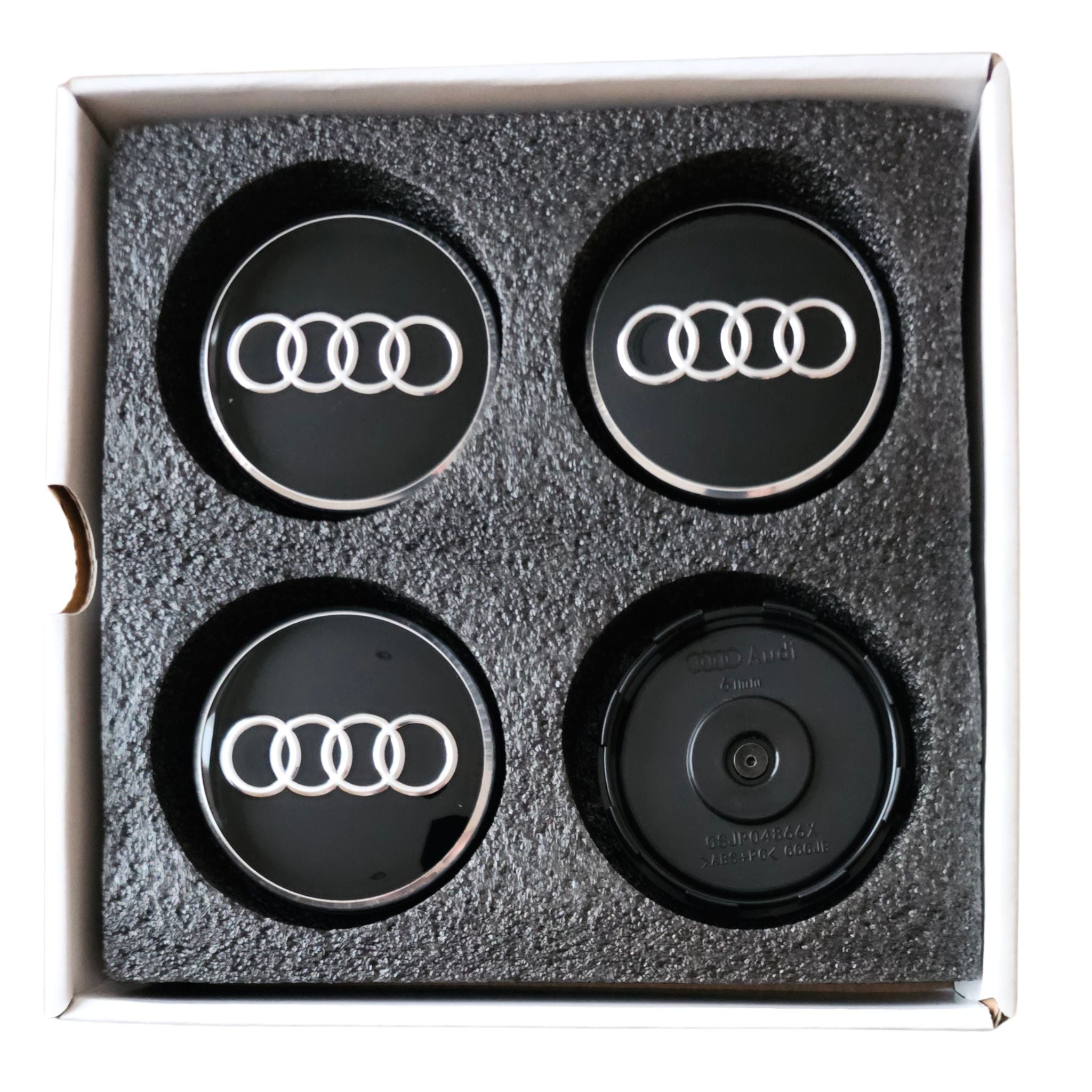 set of four Audi Dynamic Floating Wheel Centre Caps 61mm in packaging on a white background