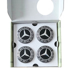 Four 75mm Mercedes-Benz Dynamic Floating Centre Caps Black inside an open white presentation box.