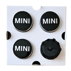 Four MINI 56mm Dynamic Floating Wheel Centre Hub Caps, one flipped to show rear view on white backing card