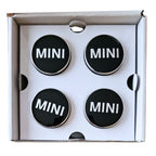 Four MINI 56mm Floating Wheel Centre Caps in open box on a white background