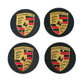Four 65mm porsche wheel centre caps in black on white background