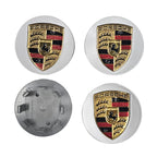 Four Porsche wheel hub caps with the brand logo emblem on a white background