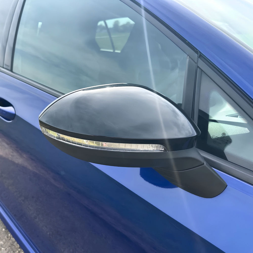 Volkswagen Golf Mk8 & Mk8.5 Gloss Black Mirror Caps Pair on a white background fitted on vehicle